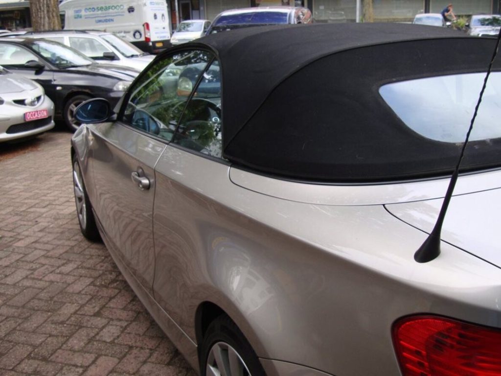 BMW 1-serie Cabrio met gesloten stoffen kap voor de garage in Haarlem