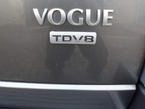 Grijze Land Rover Range Rover Vogue met trekhaak voor de garage