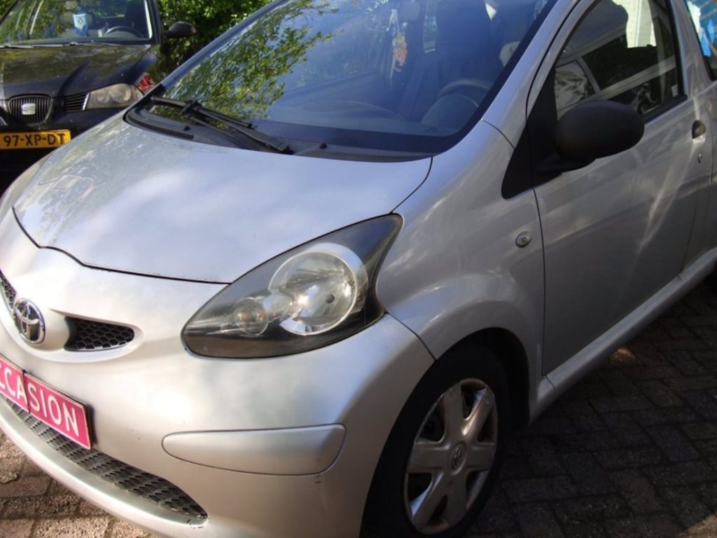 Zilvergrijze Toyota Aygo voor de garagedeuren van Garage Rapid