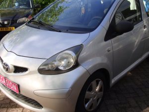 Zilvergrijze Toyota Aygo voor de garagedeuren van Garage Rapid