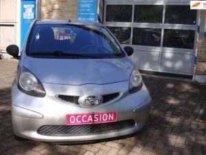 Zilvergrijze Toyota Aygo voor de garagedeuren van Garage Rapid