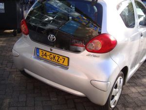 Zilvergrijze Toyota Aygo voor de garagedeuren van Garage Rapid