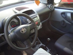 Zilvergrijze Toyota Aygo voor de garagedeuren van Garage Rapid