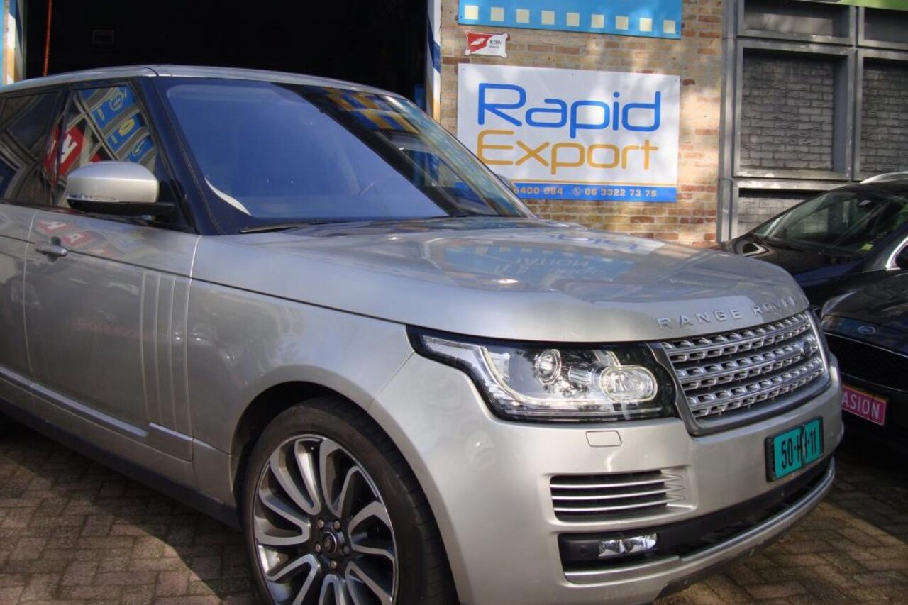 Het bord Rapid Export aan de gevel, met een Range Rover ervoor